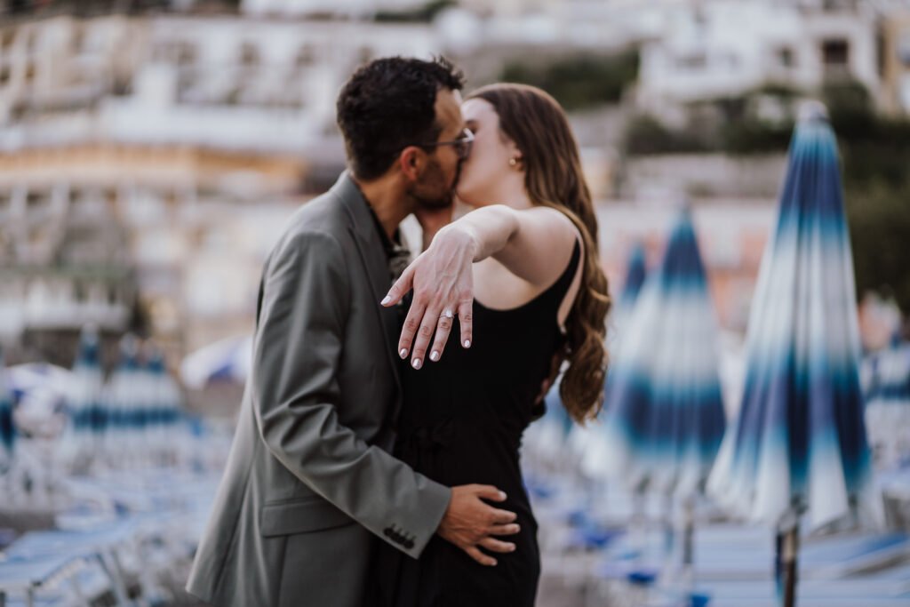 Couple kissing on the beach in Positano with engagement ring Couple kissing on the beach in Positano while showing off an engagement ring