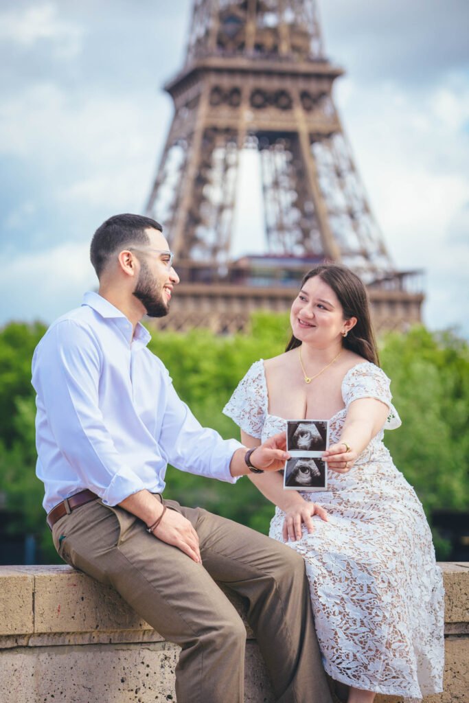Expecting couple holding ultrasound near Eiffel Tower in Paris Expecting couple holding an ultrasound photo with the Eiffel Tower in Paris in the background.