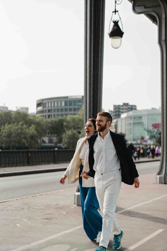 Smiling couple walking along Bir-Hakeim bridge in Paris Smiling man and woman walking together along the Bir-Hakeim bridge in Paris